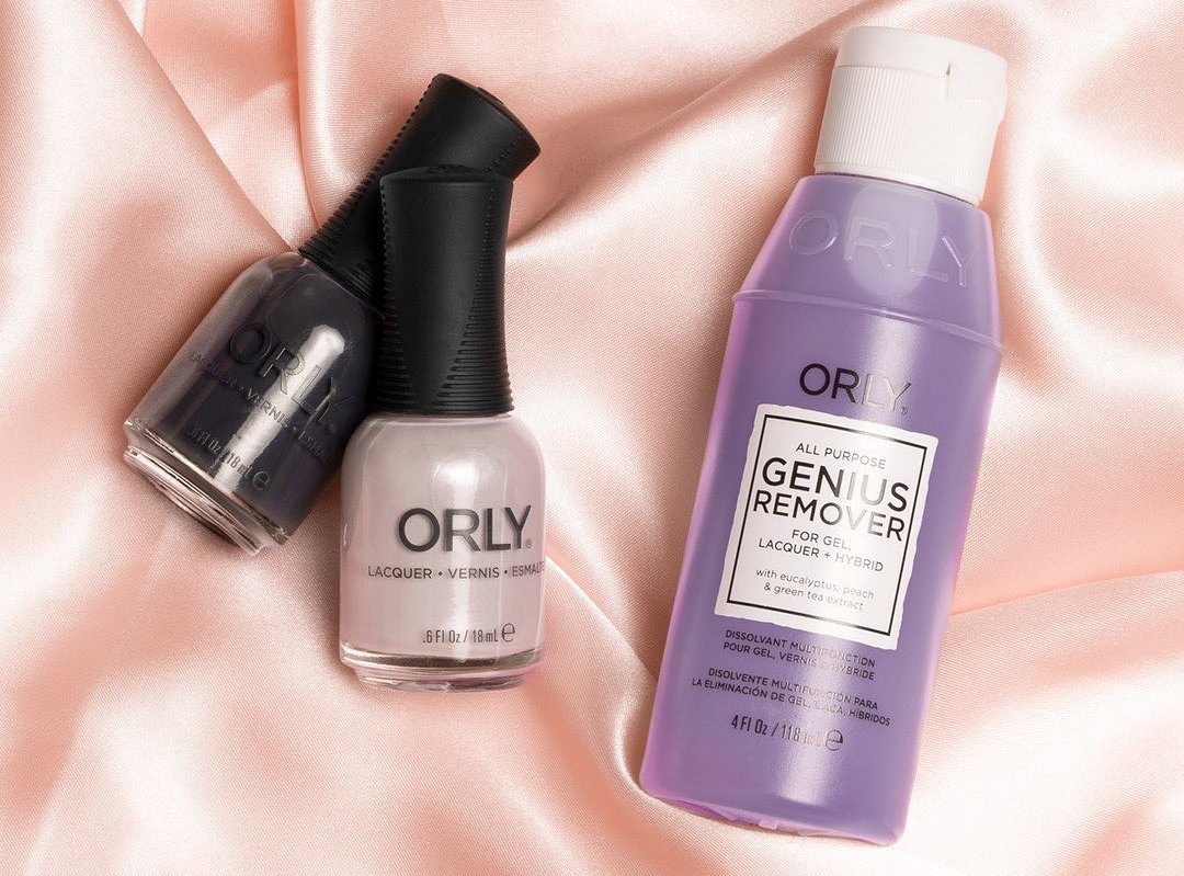 bottle of the genius remover next to two bottles of nail polish