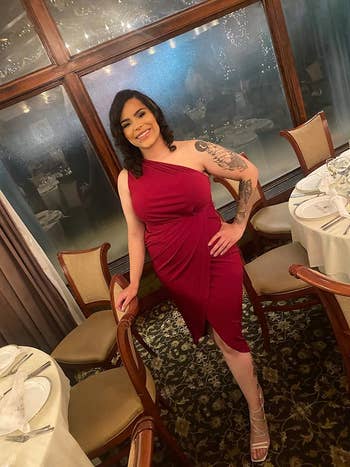 reviewer posing in red one-shoulder belted midi dress