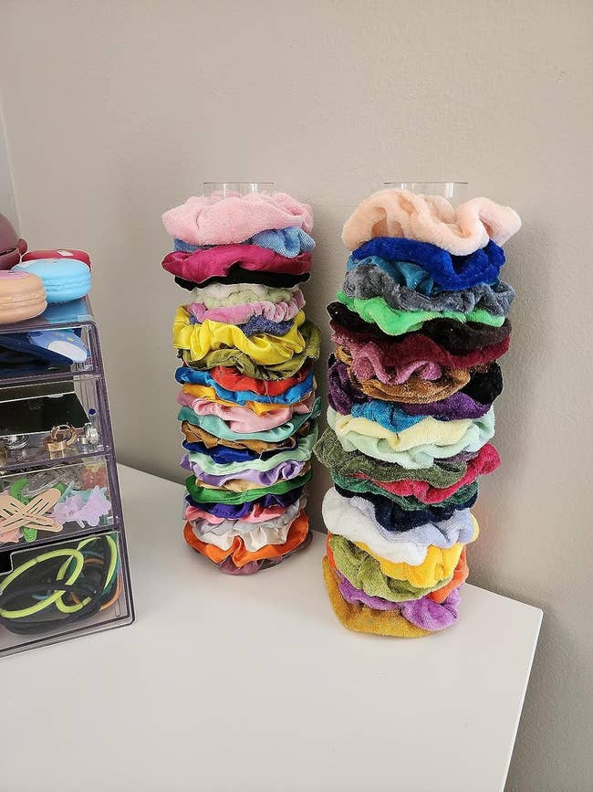 Two stacks of variously colored scrunchies on a shelf for organizing accessories