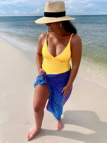 reviewer in a yellow swimsuit with a broad-brimmed hat  