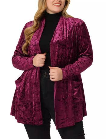 A model wearing a burgundy velvet cardigan