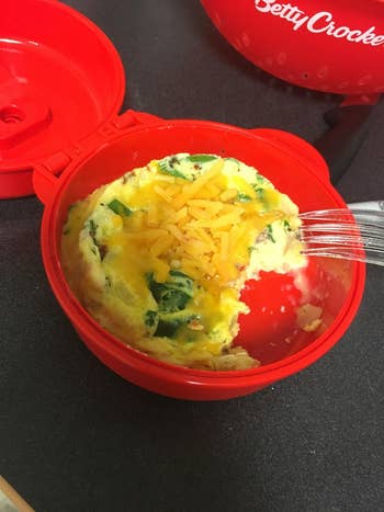 reviewer pic of the red egg cooker with cooked eggs inside