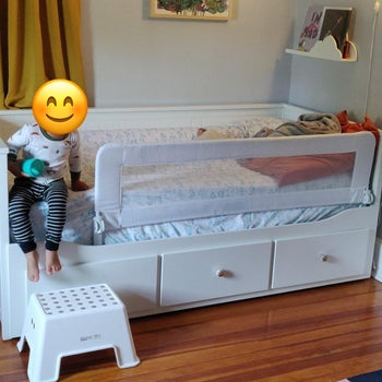reviewer photo of child getting out of their bed, which has the rail guard installed 