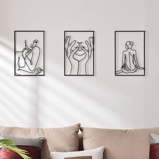 three pieces of wall art depicting various female body images with black line art