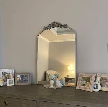 reviewer image of the silver baroque-inspired mirror on a dresser