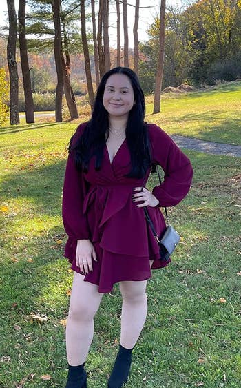 reviewer wearing the burgundy dress with boots