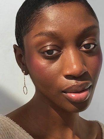 a soft natural looking blush applied to a darker skinned model