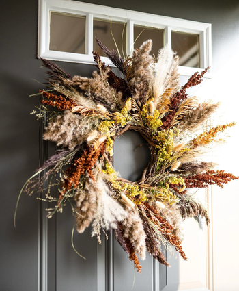 the dried floral wreath on a front door