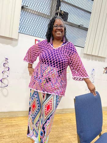 Person smiling successful a net-style apical and geometric patterned pants, lasting indoors