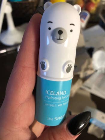 The small polar bear shaped eye stick in a reviewer's hands 