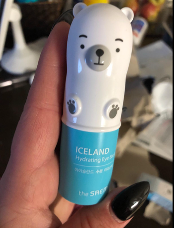 The small polar bear shaped eye stick in a reviewer's hands 