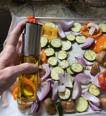 reviewer spraying vegetables with the oil spray