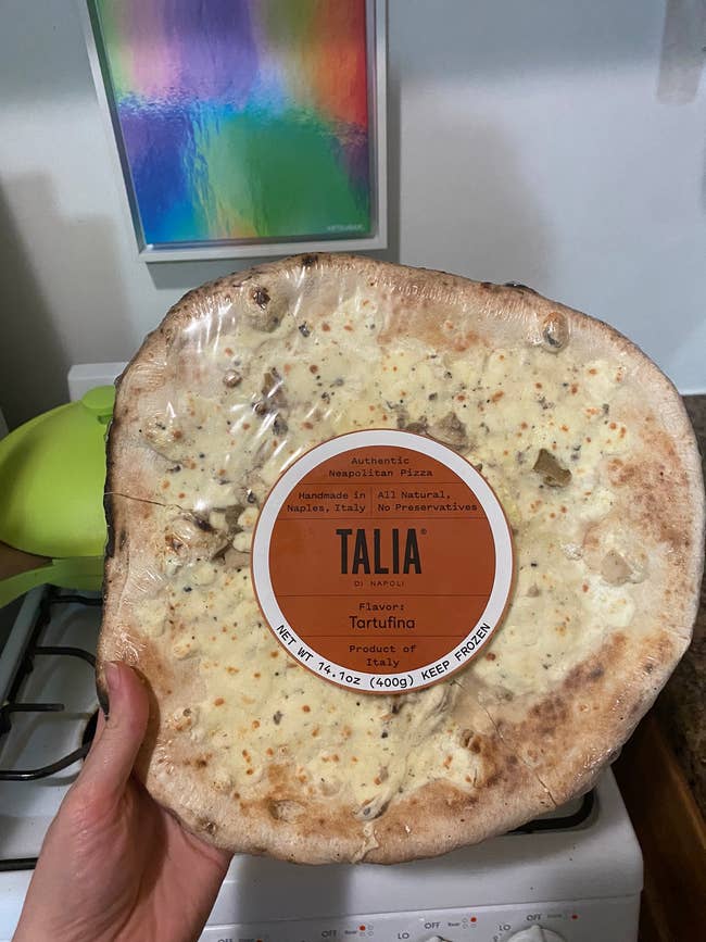 BuzzFeed editor Elizabeth Lilly holds frozen Tartufina pizza made in Italy