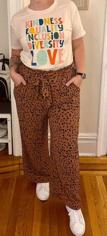 a reviewer wearing the pants featuring a brown and black leopard print 