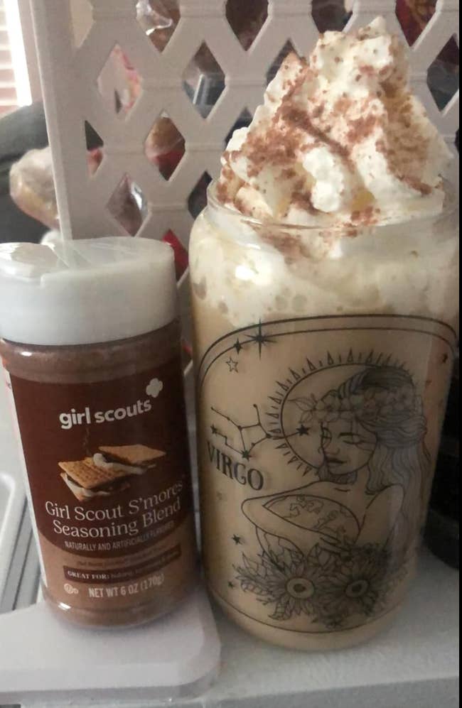 A reviewer's bottle of s'mores seasoning blend next to an iced whipped coffee