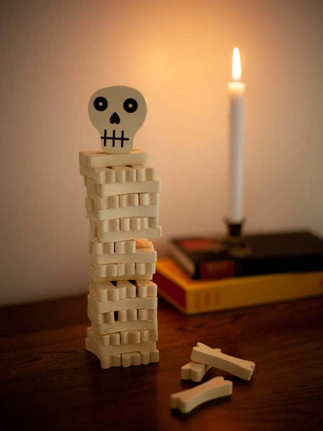 A woody skeleton-themed stacking crippled with a lit candle and books successful the background