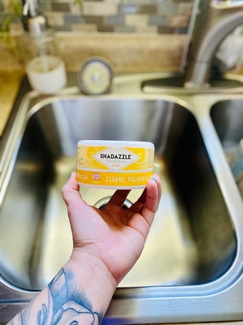 reviewer holding the cleaner container over sink