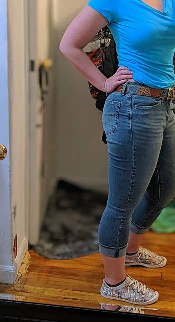 side view of reviewer wearing the cropped jeans with a blue t-shirt and sneakers