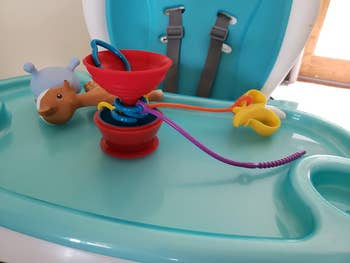 The Grapple's straps attached to toys while suctions to a highchair table