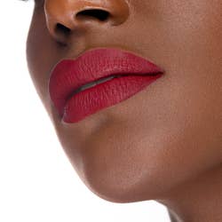 Model with darker skin tone wearing the blue-red lipstick