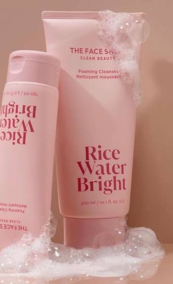 Two bottles of Rice Water Bright foaming cleanser connected  a bubbly surface