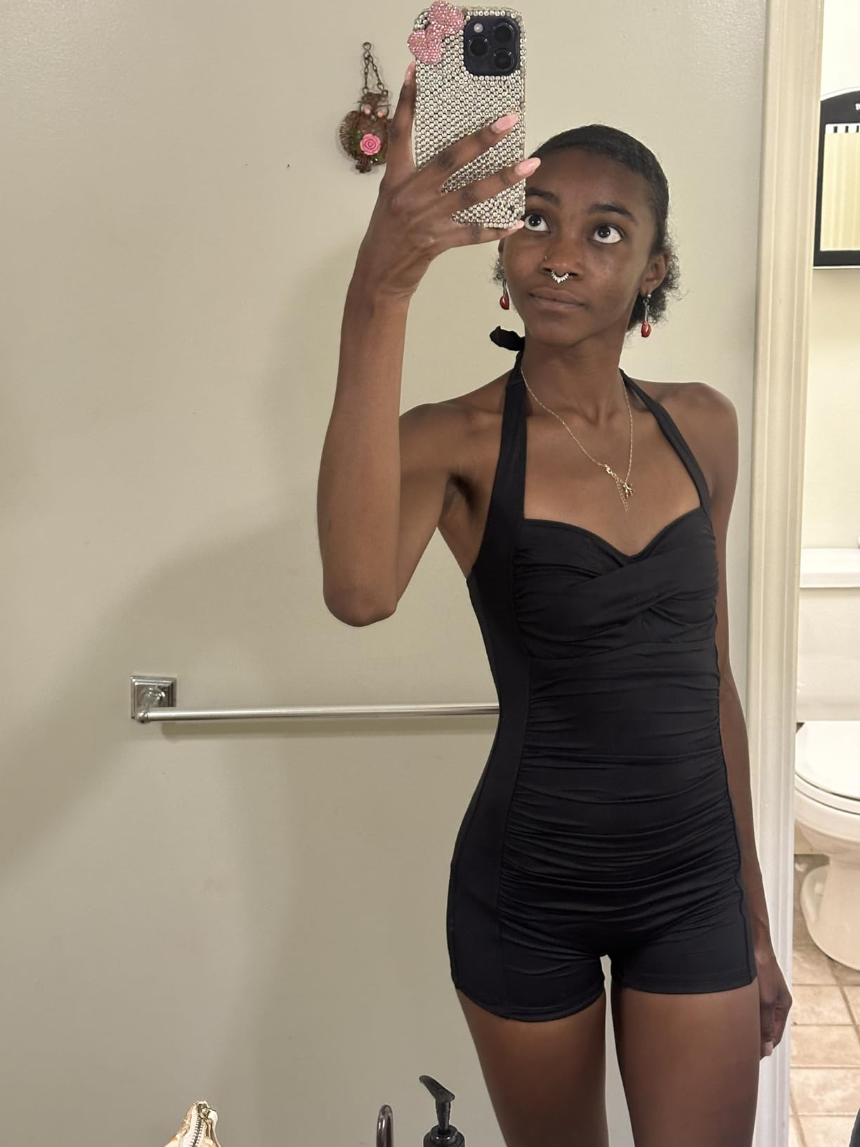 Person wearing a sleeveless achromatic  romper, taking a reflector  selfie successful  a bathroom