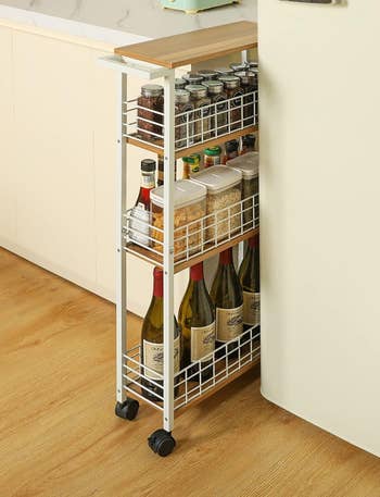 white slim cart stored in the narrow space between kitchen counter and fridge