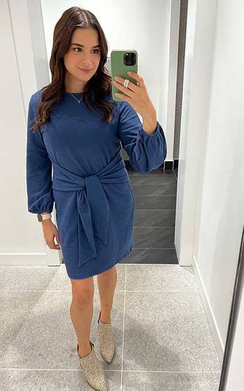 reviewer wearing the blue dress with ankle boots