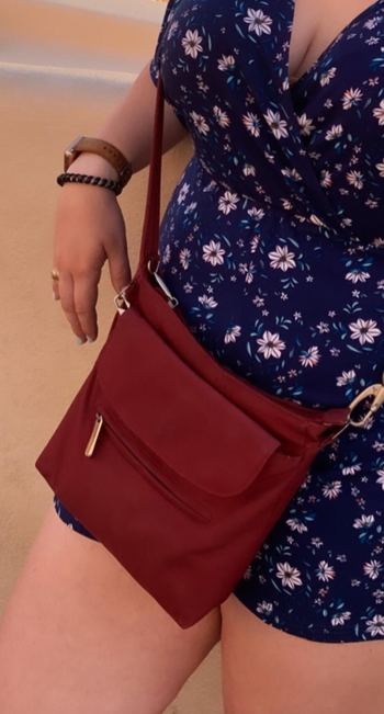 a reviewer wearing the purse crossbody in dark red 