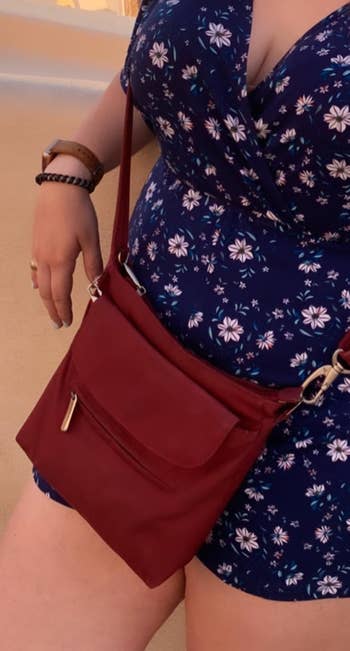 a reviewer wearing the purse crossbody in dark red 