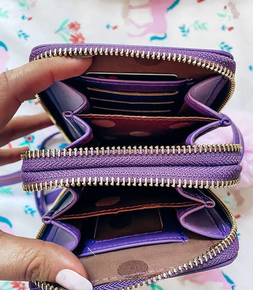 reviewer showing the different pockets and compartments in the purple crossbody phone bag