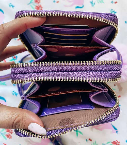 reviewer showing the different pockets and compartments in the purple crossbody phone bag