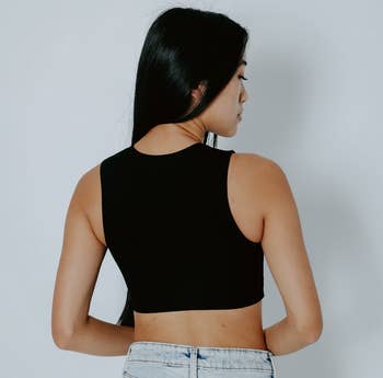 the back view of a model wearing the same shirt in black 