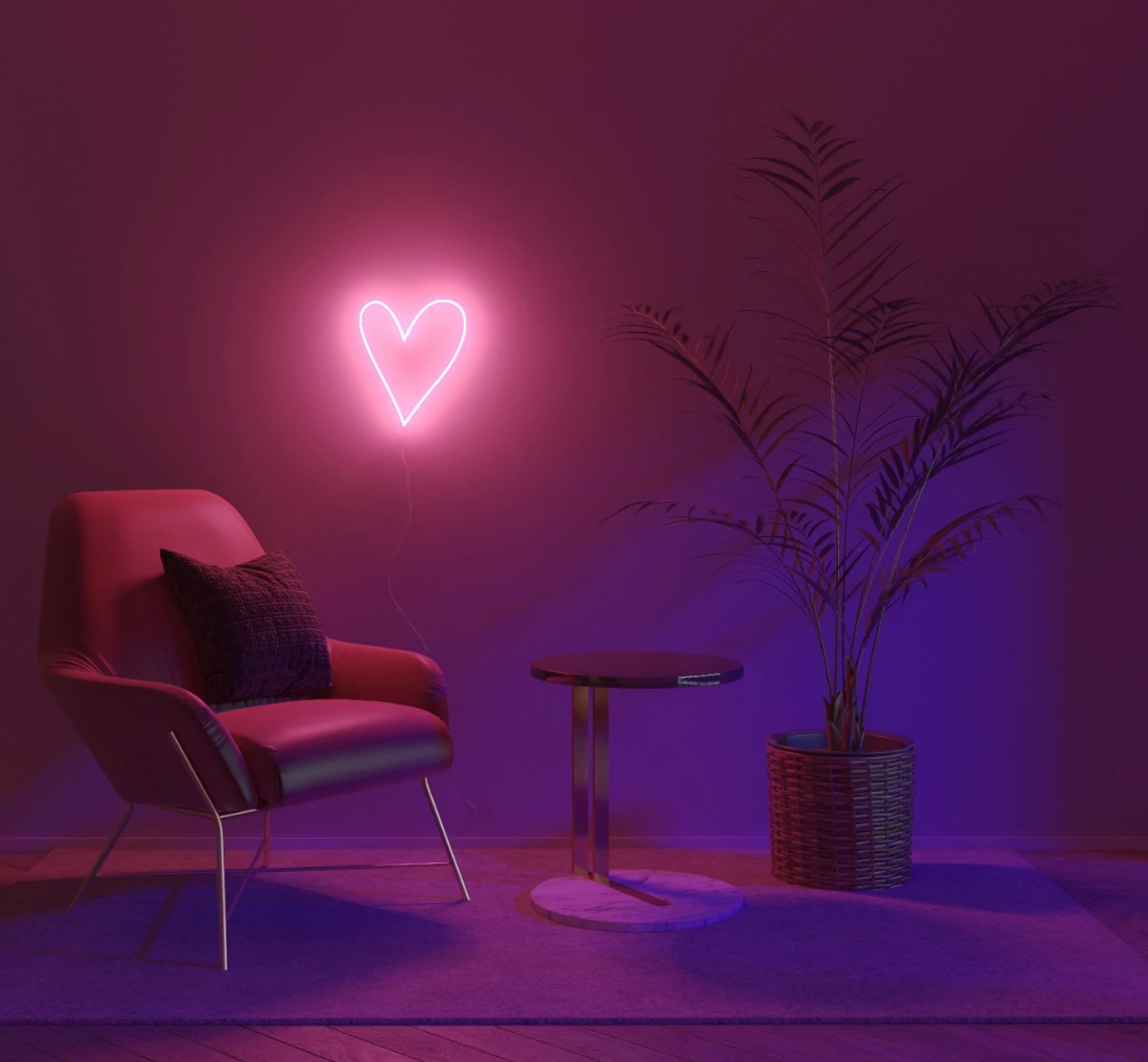 The heart shaped neon light with a pink hue lit up