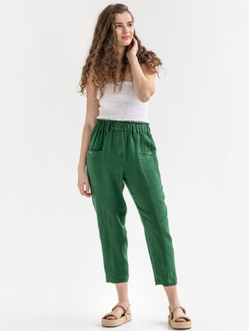 model wearing the green pants with a white tank and tan sandals