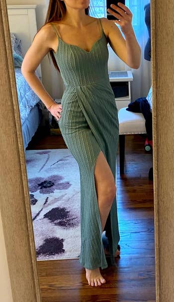 Person successful  a fitted, floor-length formal  with delicate stripes and a broadside  slit, taking a reflector  selfie successful  a bedroom