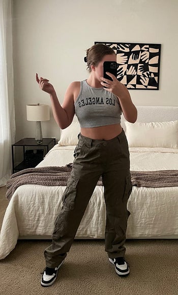 another reviewer wearing the dark green version with a cropped gray tank top and nike dunks