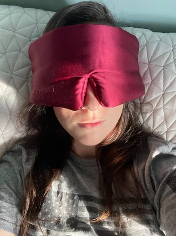 Person lying down   wearing a large, cushioned slumber  disguise  covering their eyes