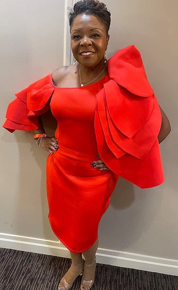 A reviewer wearing the dress in red