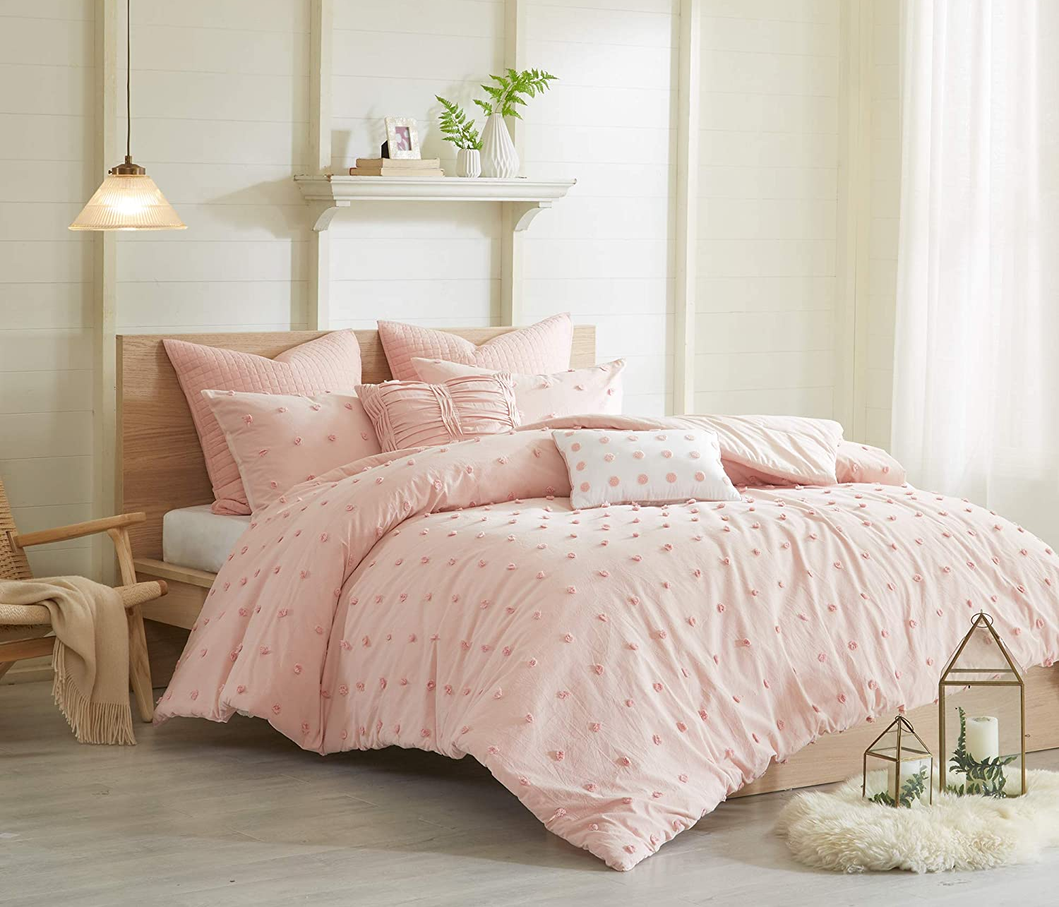 the pink pom pom comforter set on a bed