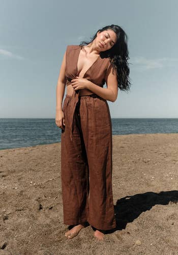 a model wearing the brown linen pants on the beach