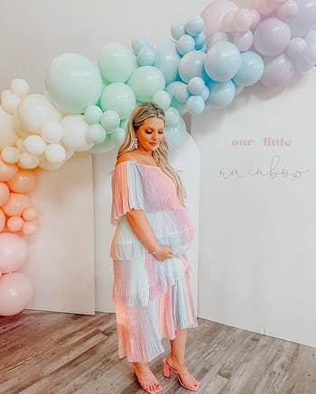 reviewer posing in pastel rainbow colored tiered dress