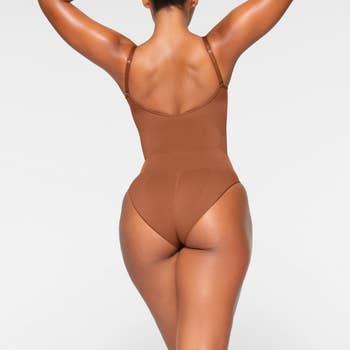 model showing back view of the light brown bodysuit 
