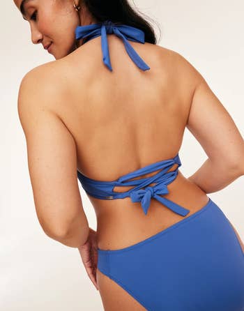 Close-up of a backless blue top with bow detailing, part of a woman's outfit