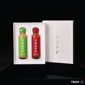 Box of two Truff hot sauce bottles, one green-labeled, one red-labeled, displayed in white packaging with gold 