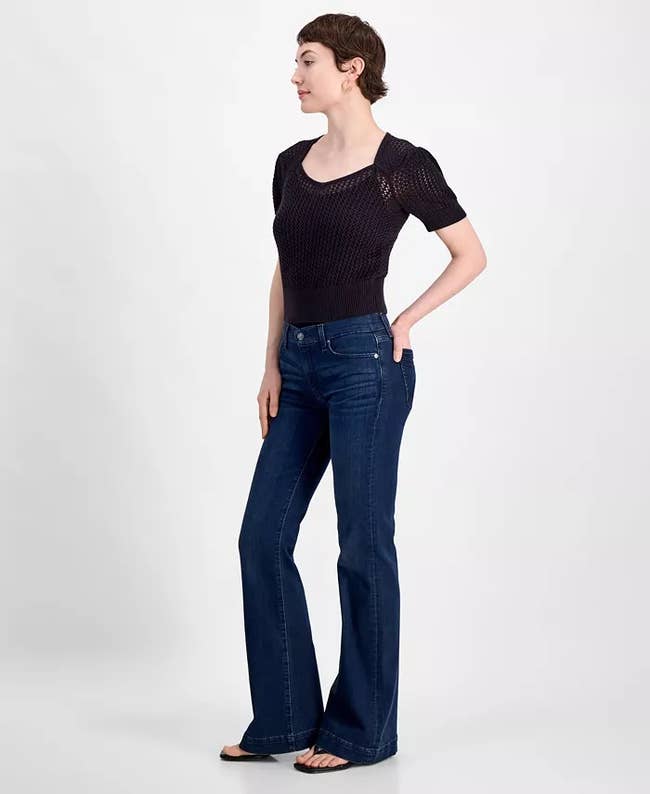 A idiosyncratic   successful  casual attire wearing a knit short-sleeve apical  and wide-leg jeans, lasting  with hands successful  pockets, suitable for daytime shopping