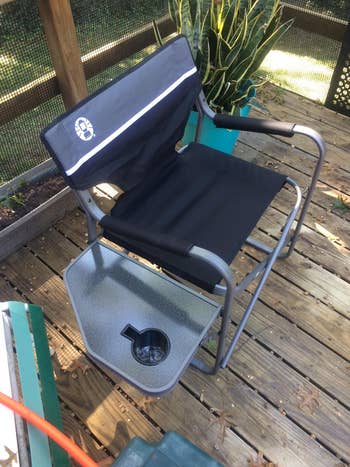 reviewer photo of the black camping chair with the side table extended out