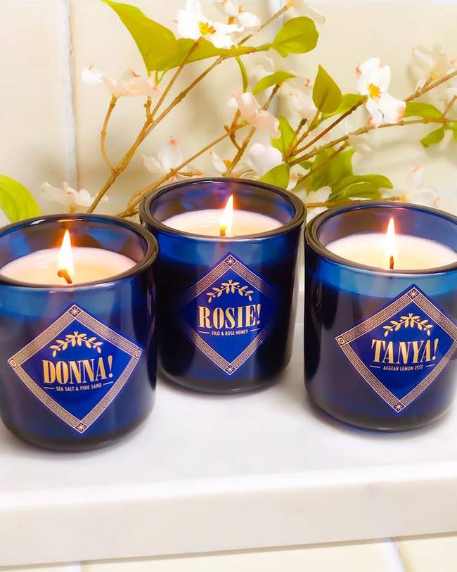 the blue candles with each lady's name and scent written on them in Mamma Mia-inspired font