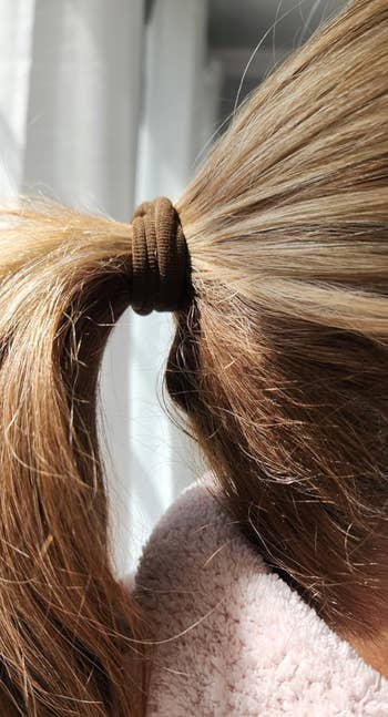 Close-up of a reviewer's hair tied in a ponytail with a brown hairband;