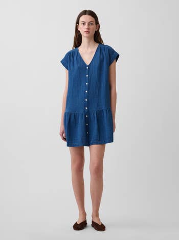 Person successful a textured, short-sleeve formal with fastener beforehand and flared skirt, wearing elemental flats